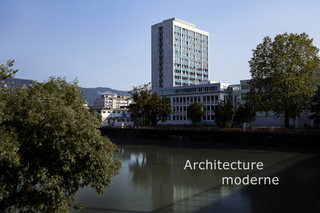 photographie d'architecture moderne à Genève en Suisse. Paysage urbain avec un canal la façade d'un immeuble de cinquante étage et les montagnes en arrière plan en été.